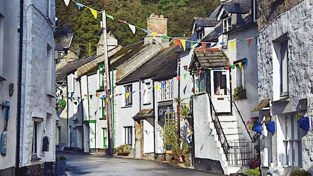 Idyllic Cornish street with whitewashed houses and colourful pennants overhead