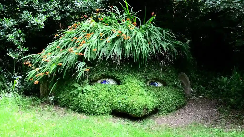 The moss-covered head of a gnome with plants for hair peeks out of the ground