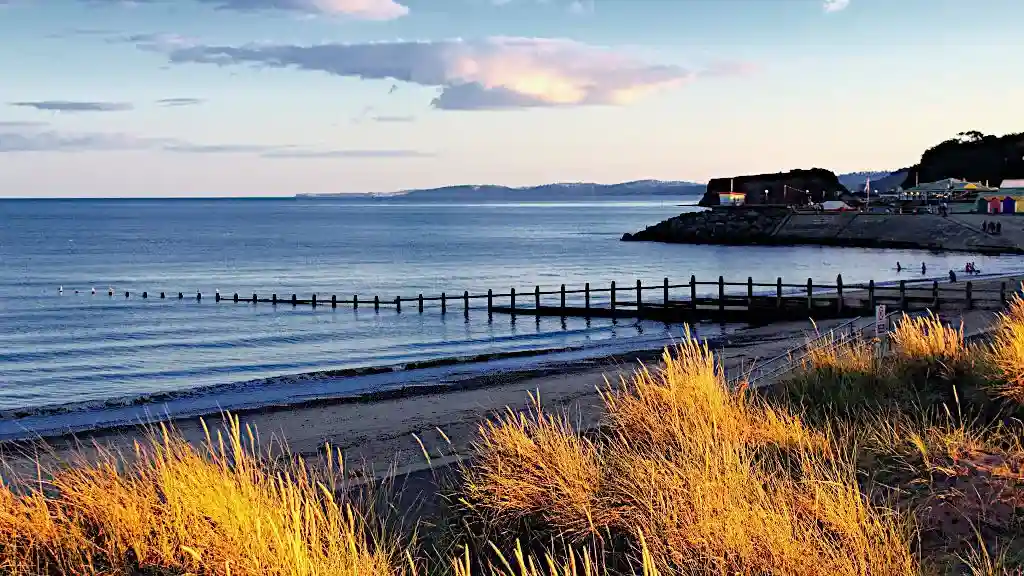 Sunset view of the ocean, a beach and a bay in Devon