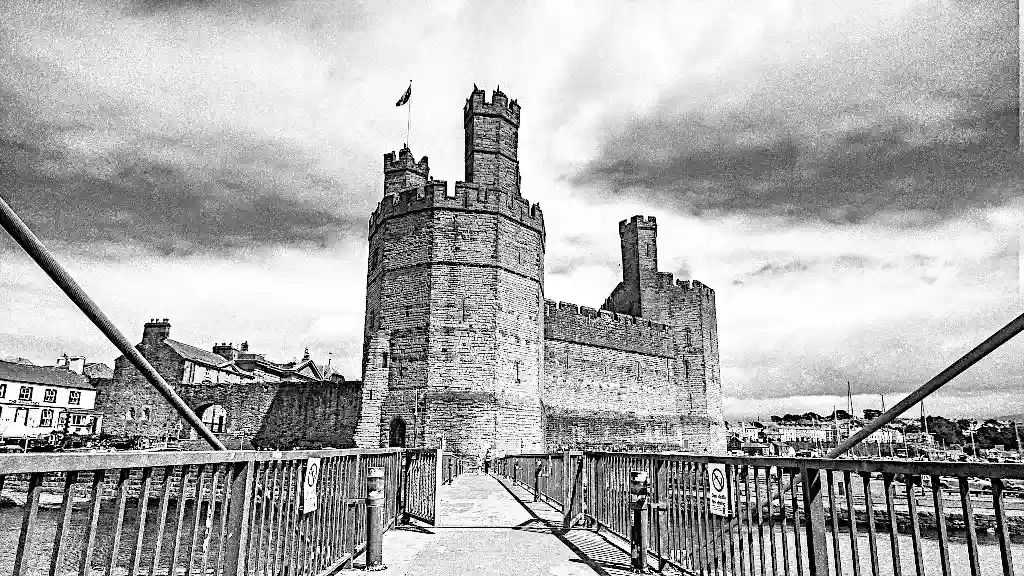 Dramatic Caernarfon castle in black and white seen from a bridge