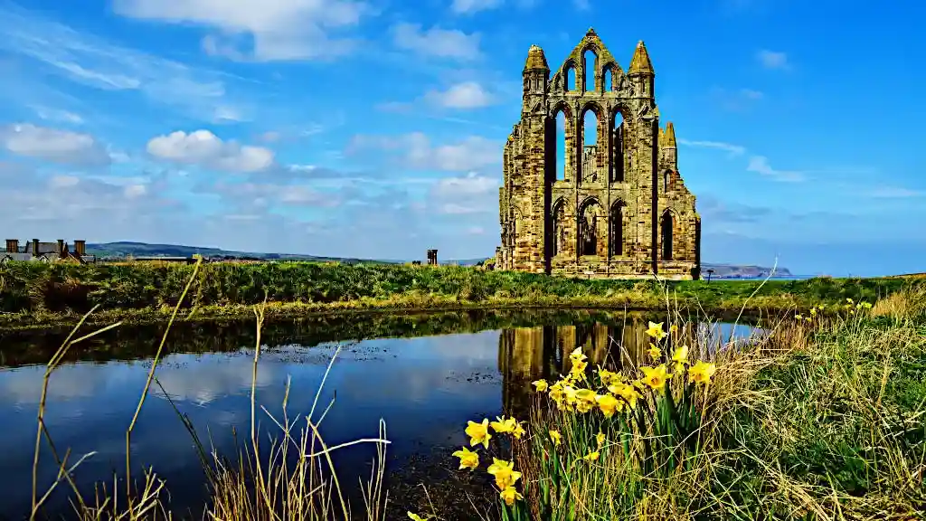 Ruins of Whitby Abbey, England, UK, reflected in the abbey pond