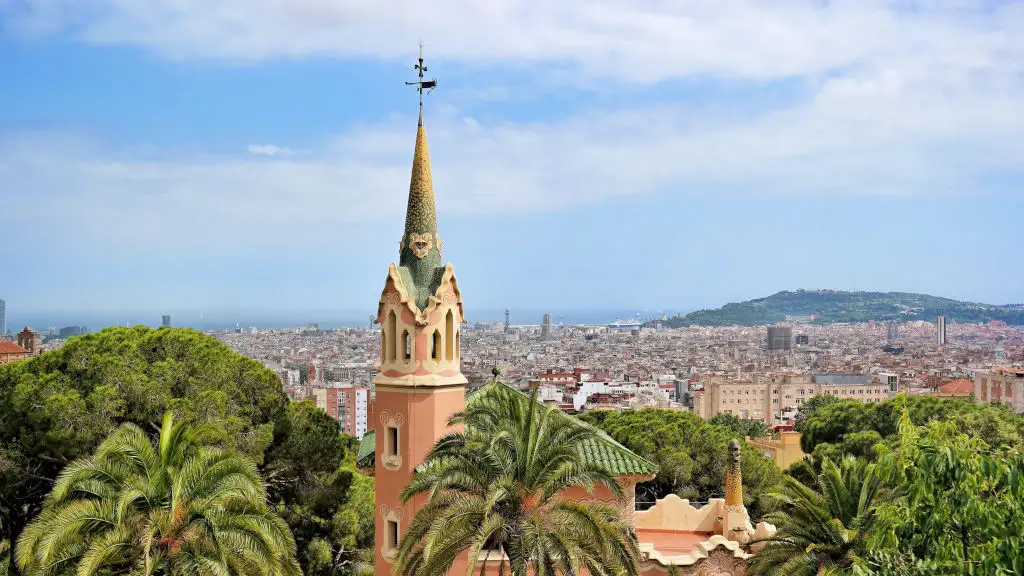 Panoramic view of Barcelona with church spire in foreground and hills in the back