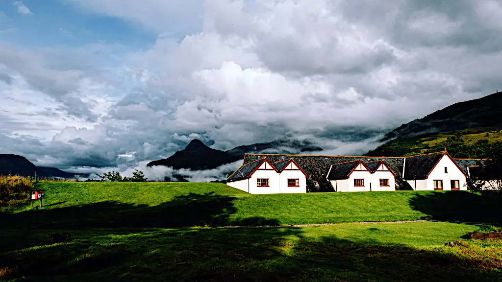 White little cottages with green lawn and mountains as backdrop